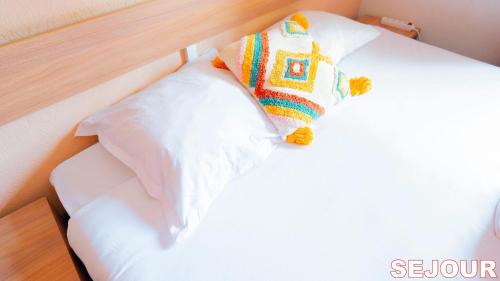 a white bed with a stuffed animal on top of it at 5 min de Paris 10 min du Zénith et Grande Halle in Pantin