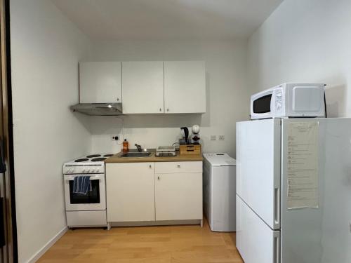 a kitchen with white appliances and a white refrigerator at Bentley Floriana Suites in Il-Furjana