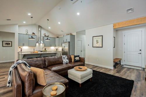 a living room with a brown leather couch and a kitchen at Lakeside Pines Retreat- Stay warm in Cozy Comfort in Pinetop-Lakeside