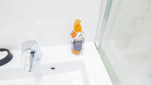 a bottle of alcohol sitting on a bathroom sink at 5 minutes de Paris T2 cocon village dIvry in Ivry-sur-Seine