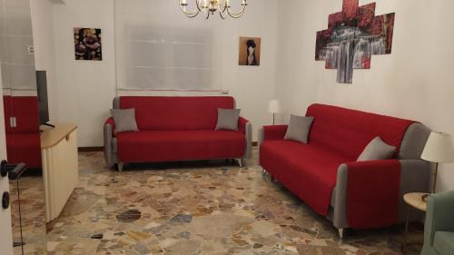 a living room with two chairs and a red couch at Residenza Magenta in Legnano