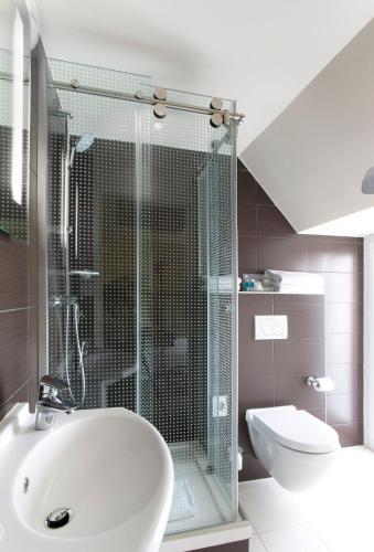 a bathroom with a shower and a sink and a toilet at Holiday Inn Paris Opéra - Grands Boulevards by IHG in Paris