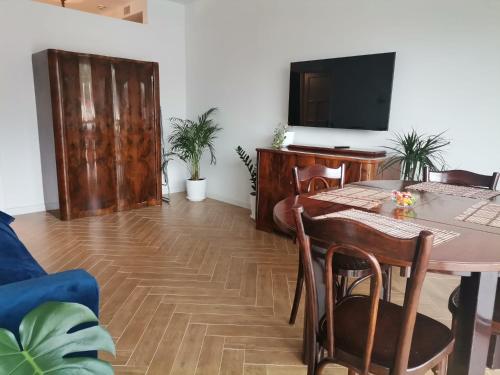 a living room with a table and a tv at Perla Sinaia in Sinaia