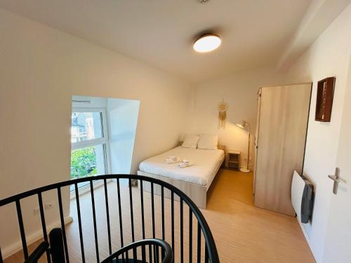 une petite pièce avec un lit et une fenêtre dans l'établissement We Live In R - Duplex 502, à Reims