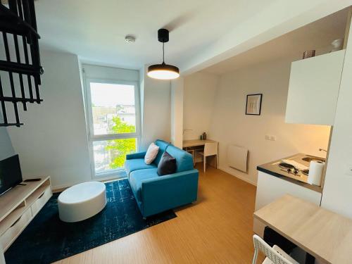 un salon avec un canapé bleu et une table dans l'établissement We Live In R - Duplex 502, à Reims