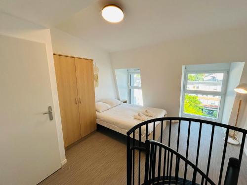 une petite chambre avec un lit et une fenêtre dans l'établissement We Live In R - Duplex 501, à Reims