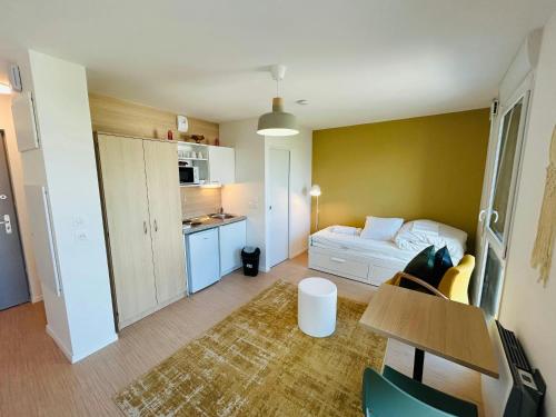 Cette petite chambre comprend un lit et une cuisine. dans l'établissement We Live In R - Suite 402, à Reims