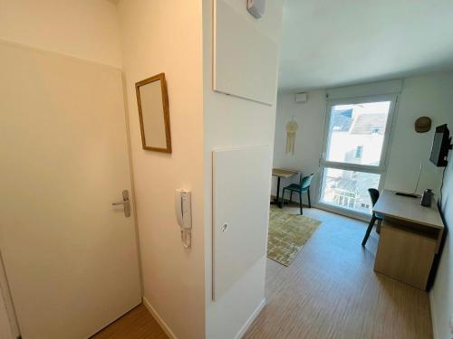 Cette chambre comprend une porte, une table et une fenêtre. dans l'établissement We Live In R - Suite 402, à Reims
