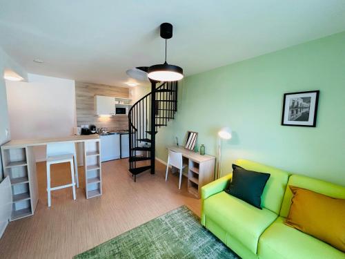 un salon avec un canapé vert et une cuisine dans l'établissement We Live In R - Duplex 504, à Reims
