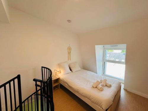 une chambre avec un lit avec un ours en peluche dessus dans l'établissement We Live In R - Duplex 504, à Reims