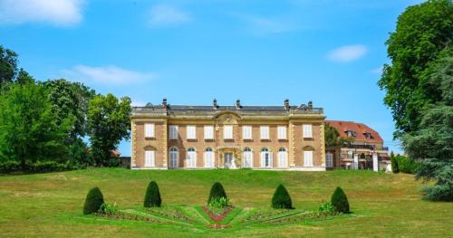 a large house on top of a grassy hill at Maison de ville proche A13 et Rouen in Oissel