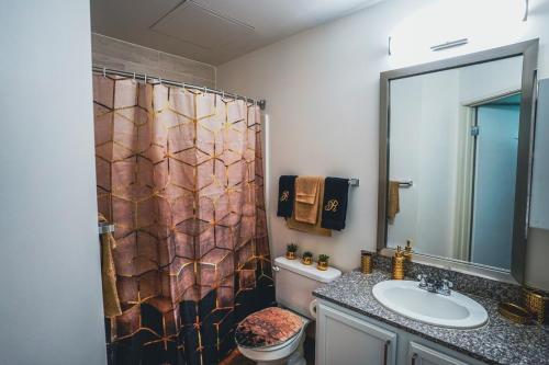 a bathroom with a shower curtain and a sink at The Grandleaf Suite at Monument Circle in Indianapolis