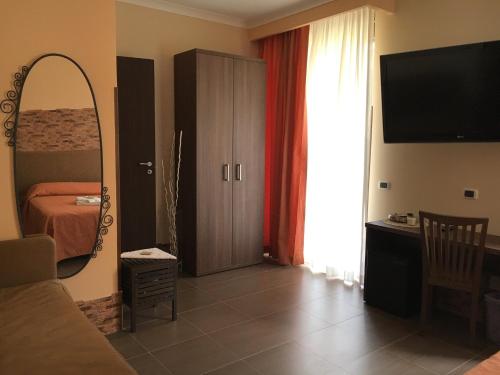 un soggiorno con letto e specchio e una camera da letto di Jadore Monic a Roma