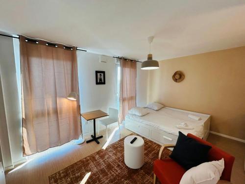 une petite pièce avec un lit et une chaise dans l'établissement We Live In R - Suite 404, à Reims