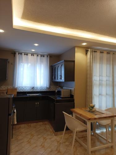a kitchen with a table and a dining room at Lerato's Apartments in Kampala