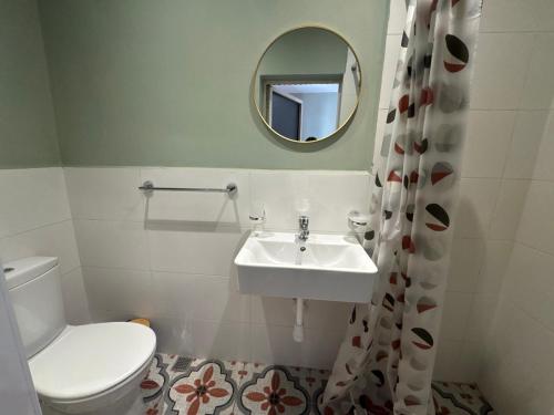 a bathroom with a sink and a toilet and a mirror at Bentley Floriana Suites in Il-Furjana