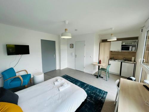 un salon avec un lit blanc et une cuisine dans l'établissement We Live In R - Suite 301, à Reims