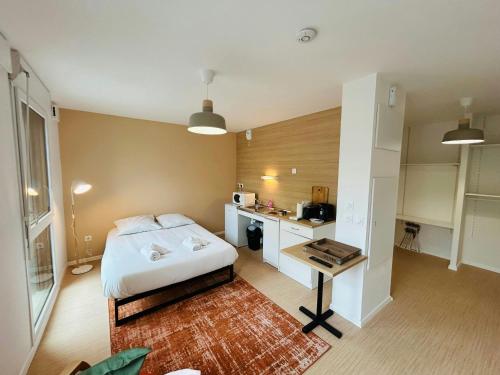 a bedroom with a bed and a desk in it at We Live In R - Suite 103 in Reims