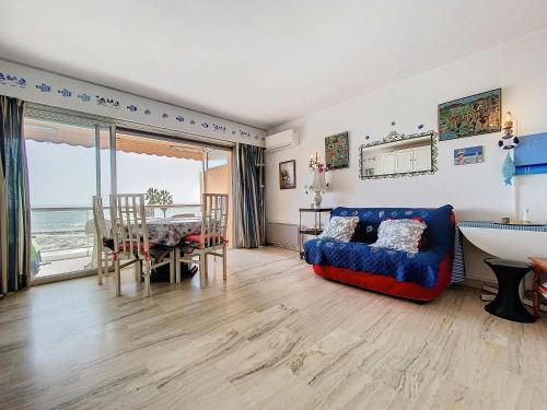 un salon avec un canapé bleu et une table dans l'établissement Emily - 2 couchages - Studio - Vue mer, au Golfe-Juan