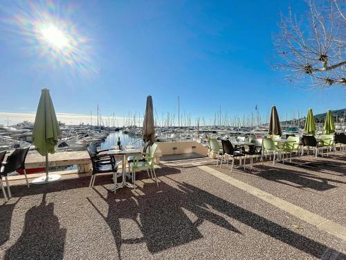 a row of tables and chairs with umbrellas on a roof at Grand Palais - 2 couchages - Studio - Vue Mer in Vallauris