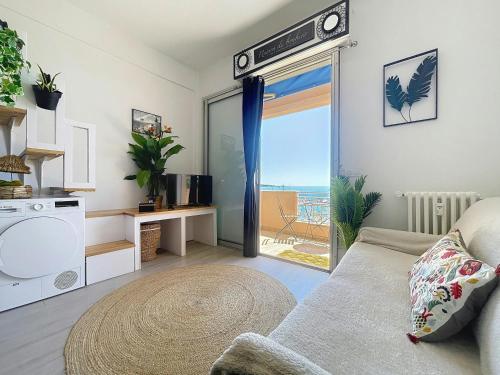 un salon avec un canapé et une porte coulissante en verre dans l'établissement Grand Palais - 4 couchages - 1mezzanine - Vue mer, au Golfe-Juan