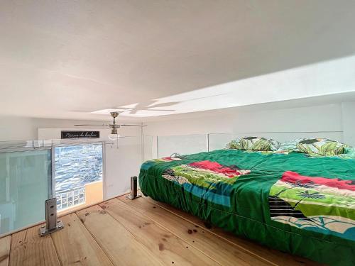 une chambre avec un lit avec une couette verte dans l'établissement Grand Palais - 4 couchages - 1mezzanine - Vue mer, au Golfe-Juan