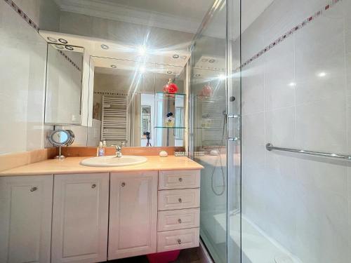 une salle de bain avec un lavabo et une douche dans l'établissement Estivalière - 6 couchages - 3 chambre - Parking, au Golfe-Juan