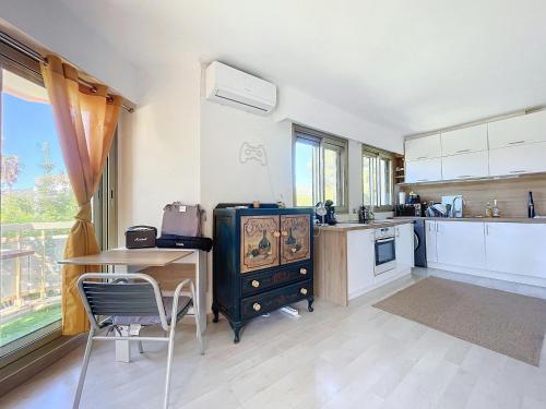 - une cuisine avec un bureau et une table avec une cuisinière dans l'établissement Residence Piscine -4 couchages -1 chambre- parking, au Golfe-Juan
