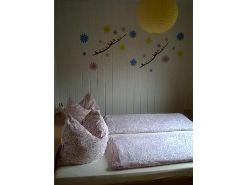 ein Schlafzimmer mit einem Bett mit Handtüchern und Blumen an der Wand in der Unterkunft Apartment at the Knappensee in Groß Särchen in Neufriedersdorf