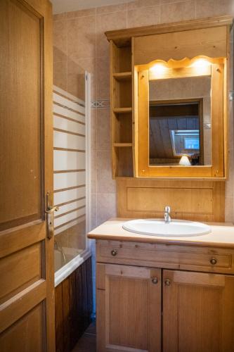 une salle de bain avec un lavabo et un miroir dans l'établissement Résidence Les Balcons de La Rosière, à La Rosière