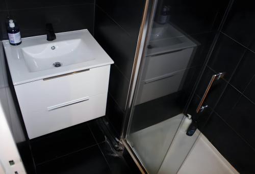 une petite salle de bain avec un lavabo et une douche dans l'établissement Superbe appartement 5pièces 2 SDB 2WC standing, à Créteil