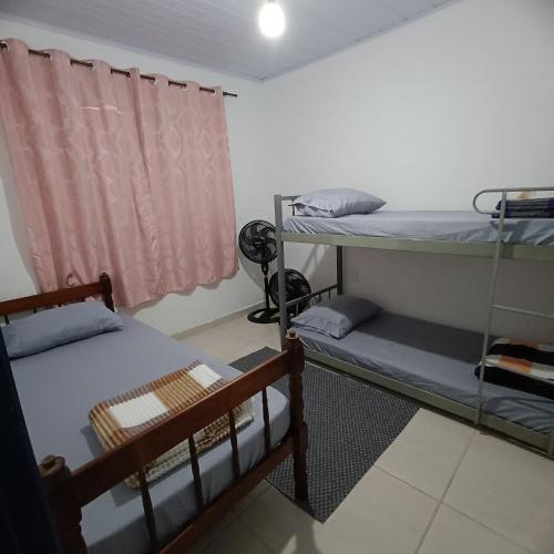 una habitación con dos literas y una ventana en Lar, doce mar., en Paraty