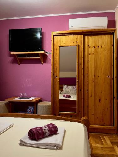 a room with a bed and a mirror and a tv at Apartments Tratinčica in Seliste Dreznicko
