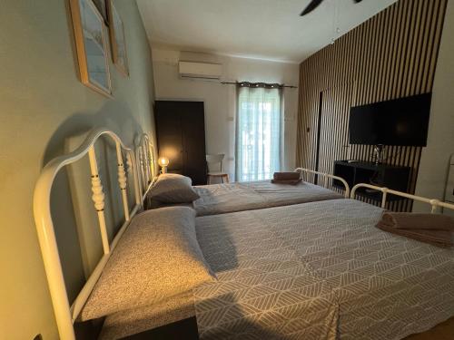 a bedroom with two beds and a flat screen tv at Bentley Floriana Suites in Il-Furjana