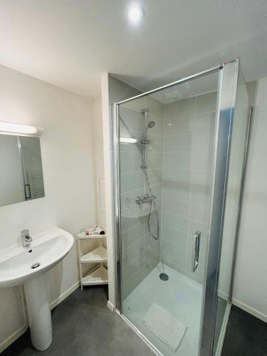une salle de bain avec une douche en verre et un lavabo dans l'établissement We Live In R - Suite 403, à Reims