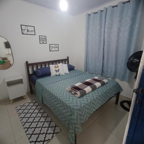1 dormitorio con 1 cama con cortina azul en Lar, doce mar., en Paraty