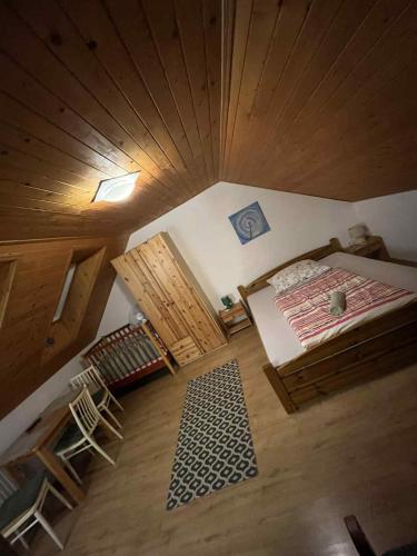 an attic room with a bed and a wooden ceiling at Green cottage Besenova in Bešeňová