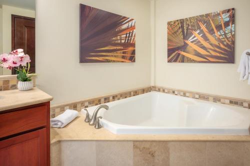 a bathroom with a large white bath tub at Waipouli Beach Resort and Spa Kauai by OUTRIGGER in Kapaa
