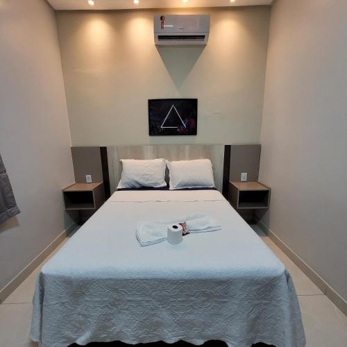 a bedroom with a bed with a tv on the wall at Pousada Loft Marabá in Marabá