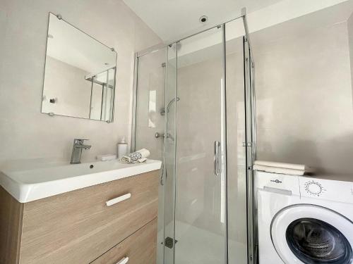une salle de bain avec une machine à laver et un lavabo dans l'établissement Studio Centreville Golfe Juan-2 couchages-Terrasse, au Golfe-Juan
