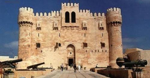 ein großes Backsteingebäude mit zwei Türmen und Menschen davor in der Unterkunft SUN SEA HOLIDAy 13 ALMOAYYED STREET in Alexandria