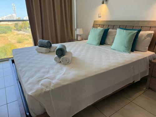 a bedroom with a large bed with towels on it at Too Coool 1 Bedroom Apartment Coralli Resort in Protaras