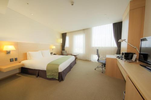 a hotel room with a bed and a desk at Holiday Inn Gwangju by IHG in Gwangju