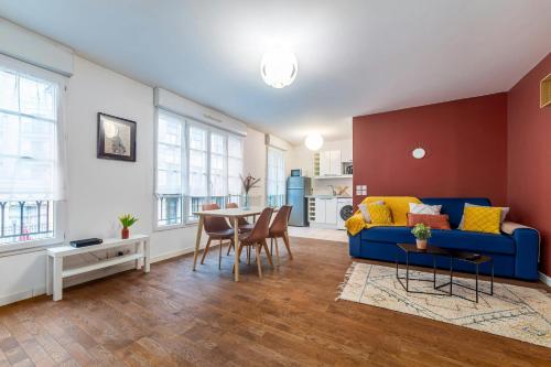 un salon avec un canapé bleu et une table dans l'établissement Vercoatta Cocon Appart - Near to Disneyland, à Serris