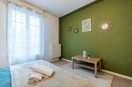 - une chambre verte avec un lit et une table dans l'établissement Vercoatta Cocon Appart - Near to Disneyland, à Serris