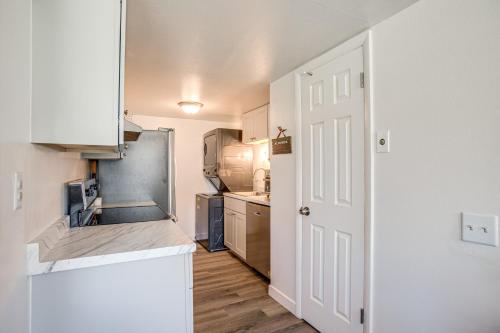 a small kitchen with a sink and a refrigerator at Explore Red Rocks and Green Mtn Townhome with Pool! in Lakewood