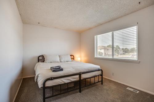 a bedroom with a bed in a room with a window at Explore Red Rocks and Green Mtn Townhome with Pool! in Lakewood