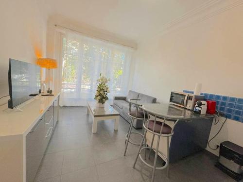 une cuisine et un salon avec une table et un canapé dans l'établissement Charmant 2 pièces 600m plage 1km de la gare, à Nice