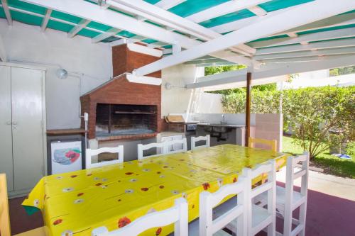 ein Esszimmer mit einem gelben Tisch und weißen Stühlen in der Unterkunft hosteria Dalmacia in Pinamar