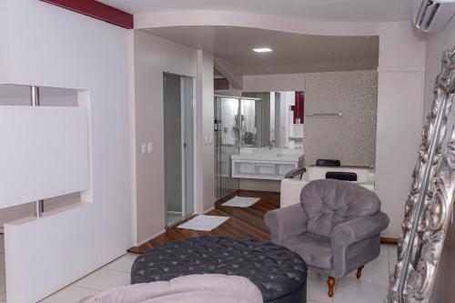 a living room with a couch and a chair at Maison Hotel - Tangará da Serra in Tangara da Serra